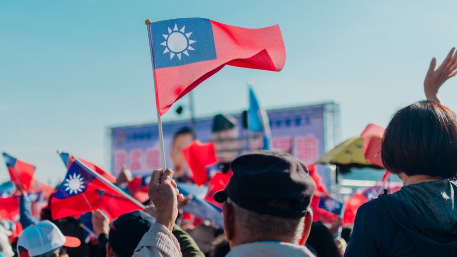 a photo of a crowd with a man waving a taiwanese flag in the center