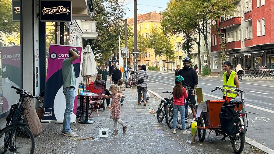 View of the Weichselstraße block party in Berlin with some people on the street and a small child playing