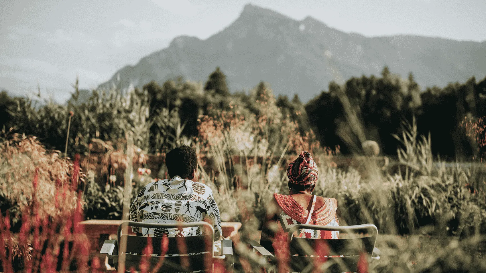 Two peole sitting in the Schloss Gardens and enjoying the scenic view of the Untersberg