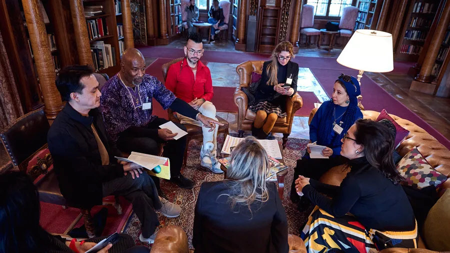 A group of Fellows discuss together in the Max Reinhardt Library during the Salzburg Global session on “Creating Futures: Art of Narrative” in April 2025.