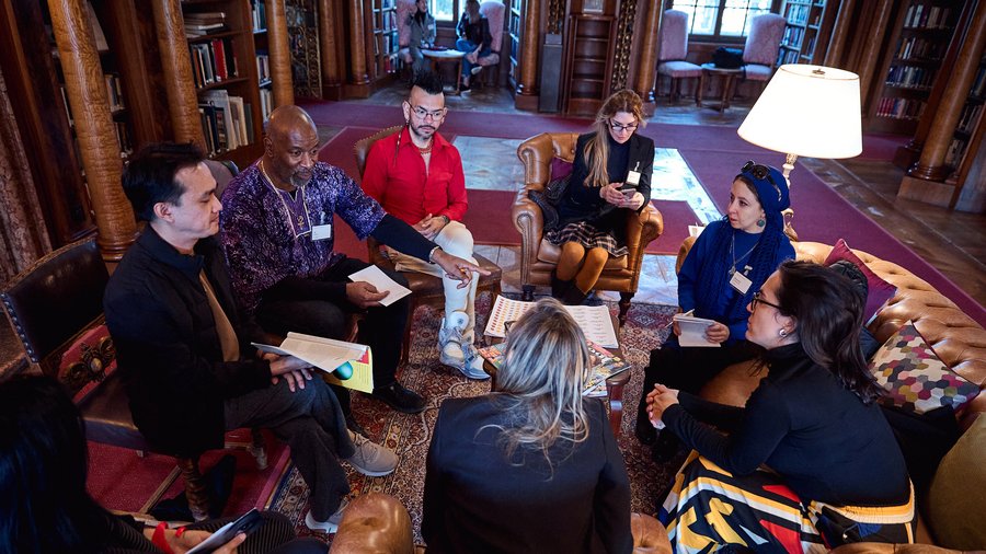 A group of Fellows discuss together in the Max Reinhardt Library during the Salzburg Global session on “Creating Futures: Art of Narrative” in April 2025.