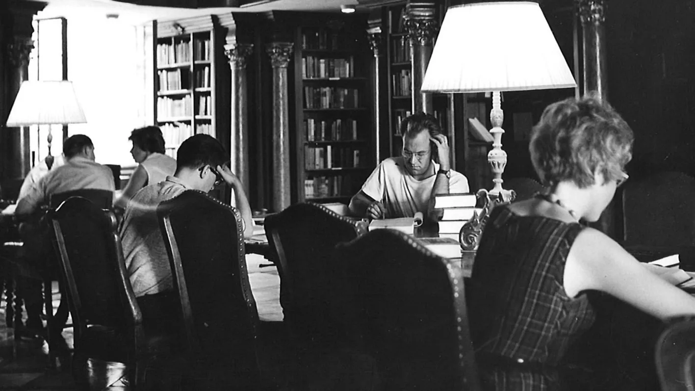 Black and White Photo of the Library With People Sitting at Desks