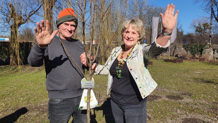 Clare Shine and her husband Mike pose next to a new tree in the Schloss Park