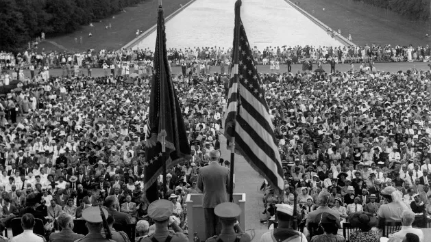 President Harry S. Truman speaks from a rostrum on the steps of the Lincoln Memorial, as he addresses the closing session of the 38th annual conference of the National Association for the Advancement of Colored People (NAACP). Reflection pool and the Washington Monument are in background.