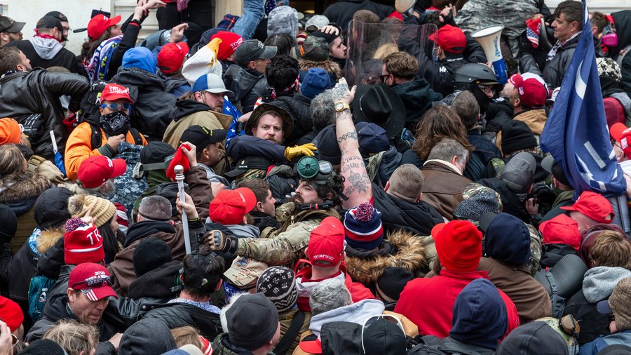 Washington, DC - January 6, 2021: A group of rioters clash with police trying to enter the U.S. Capitol building through the front doors