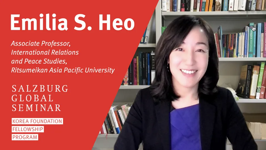 Emilia sitting in front of a bookshelf digital background