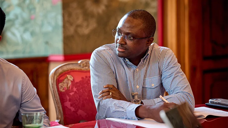 a man wearing glasses and a plaid shirt looks attentively to the left