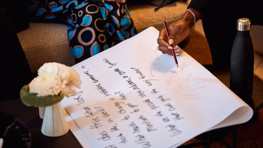 a hand writes on a paper that already has writing on it.