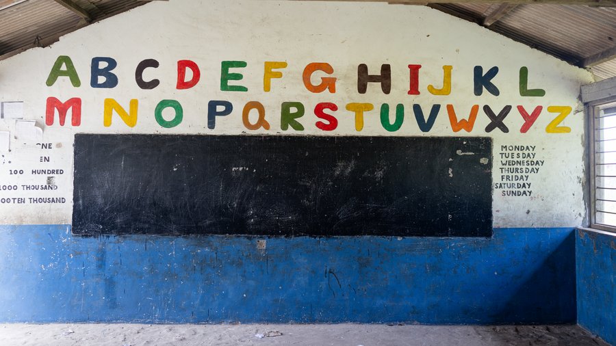 Empty school classroom with a blackboard and colorful alphabet on the wall