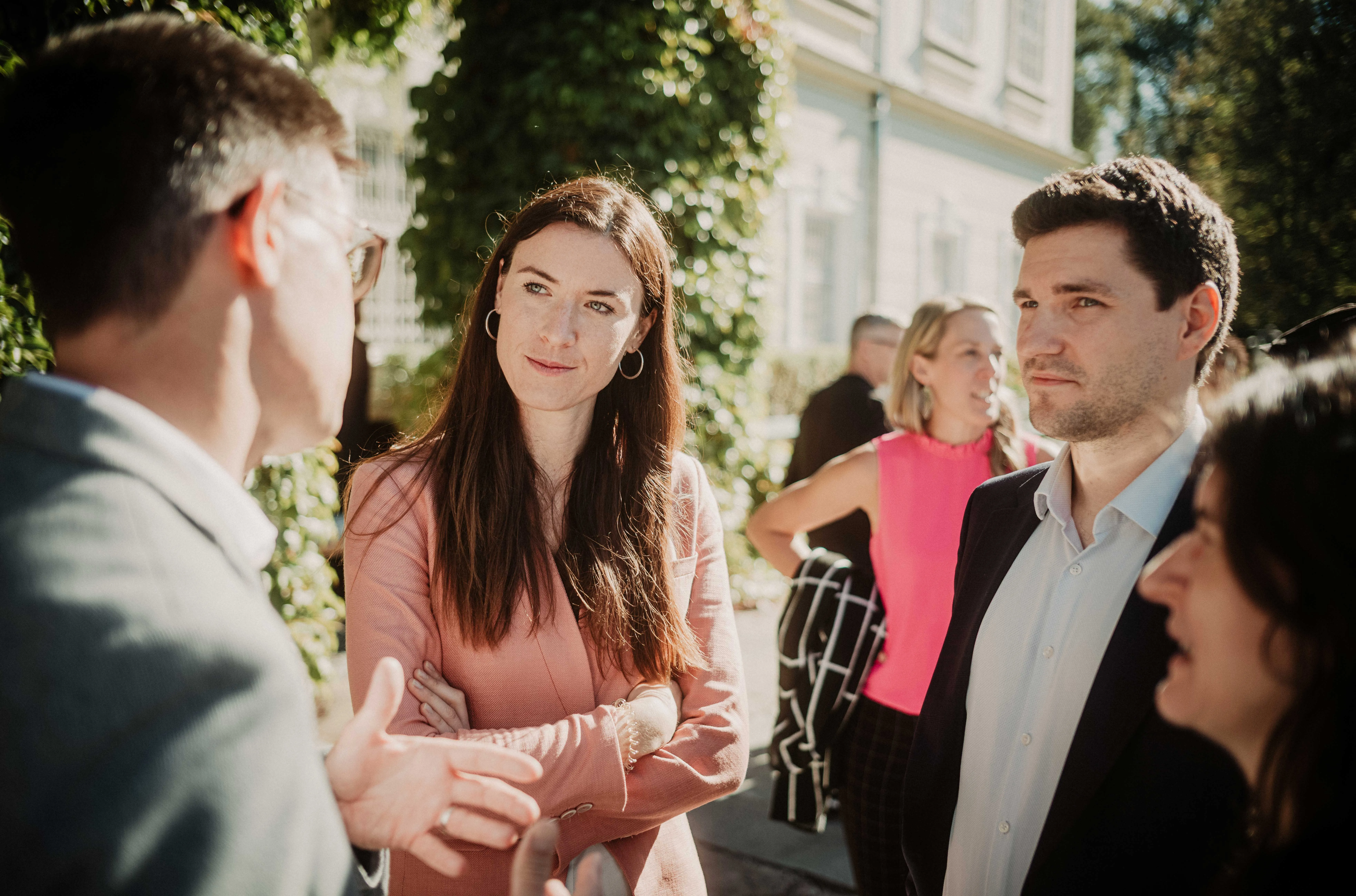 Group of Two Men and One Woman Talking in Front to the Schloss