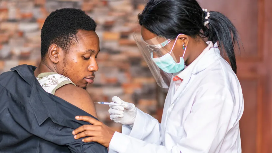 Medical personnel administers a vaccine to a patient.
