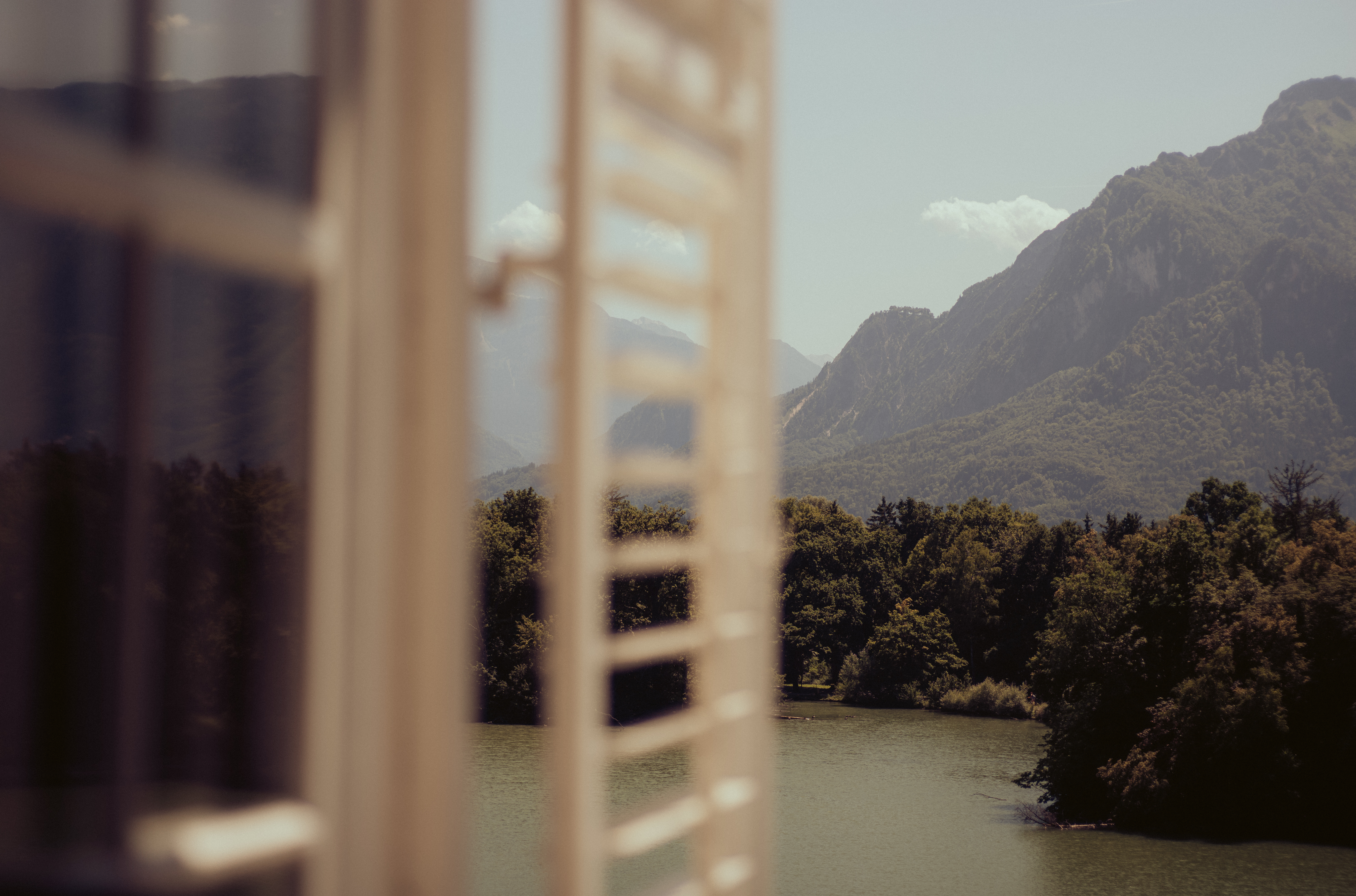 mountain view out of a window with window shutters blurred in view