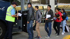 A line of Central American migrants seeking asylum board a greyhound bus in McAllen, Texas in April 2019.